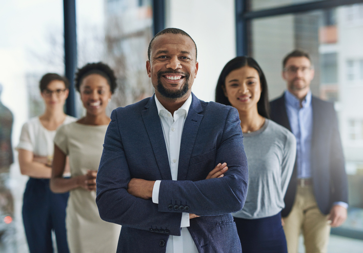 Cropped shot of a group of businesspeople standing in the office